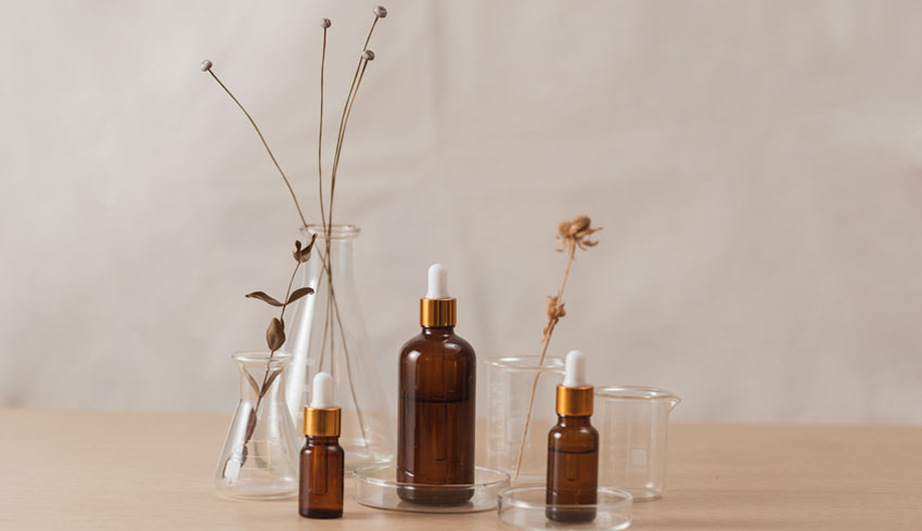 A display of empty skin care containers, some holding plants.